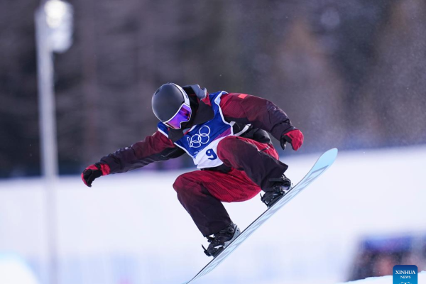 A snowboarder performs a trick during the Winter Olympics halfpipe qualification.