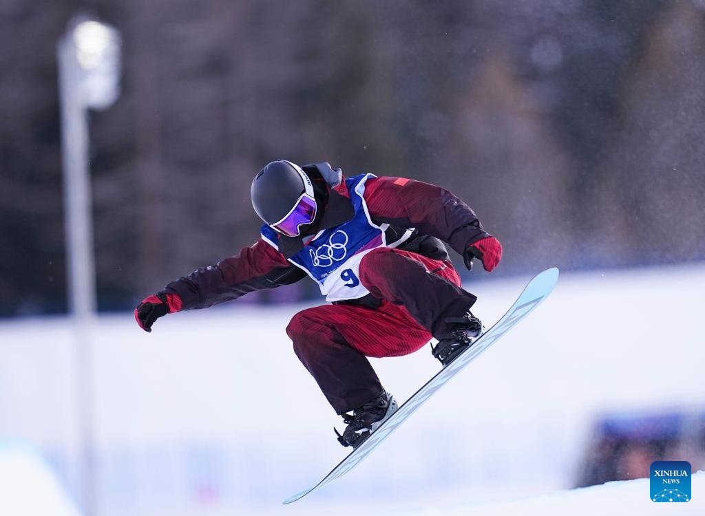 A snowboarder performs a trick during the Winter Olympics halfpipe qualification.