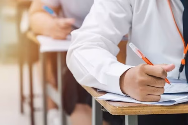 Students entering a center for the Lahore Matric Exams 2026 under security.