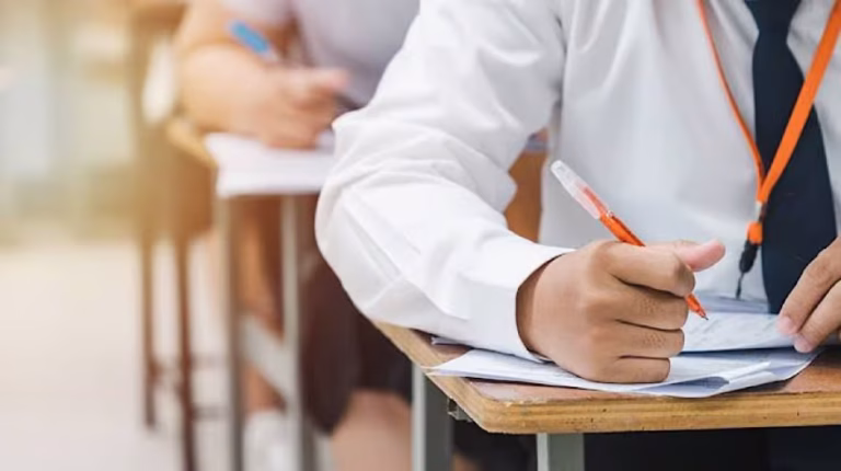Students entering a center for the Lahore Matric Exams 2026 under security.